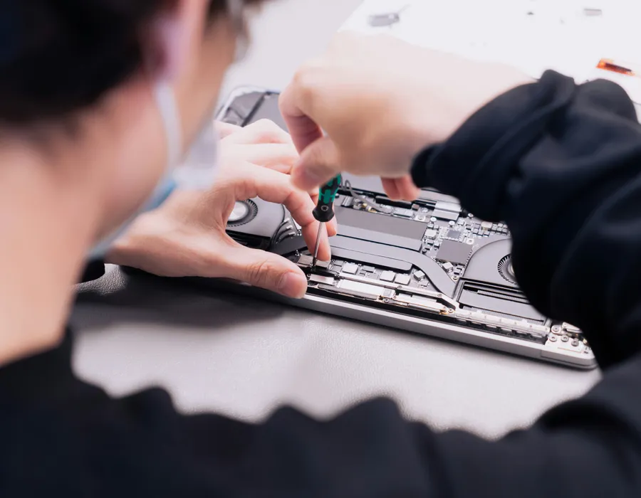 Técnico desmontando a carcaça de um notebook na bancada