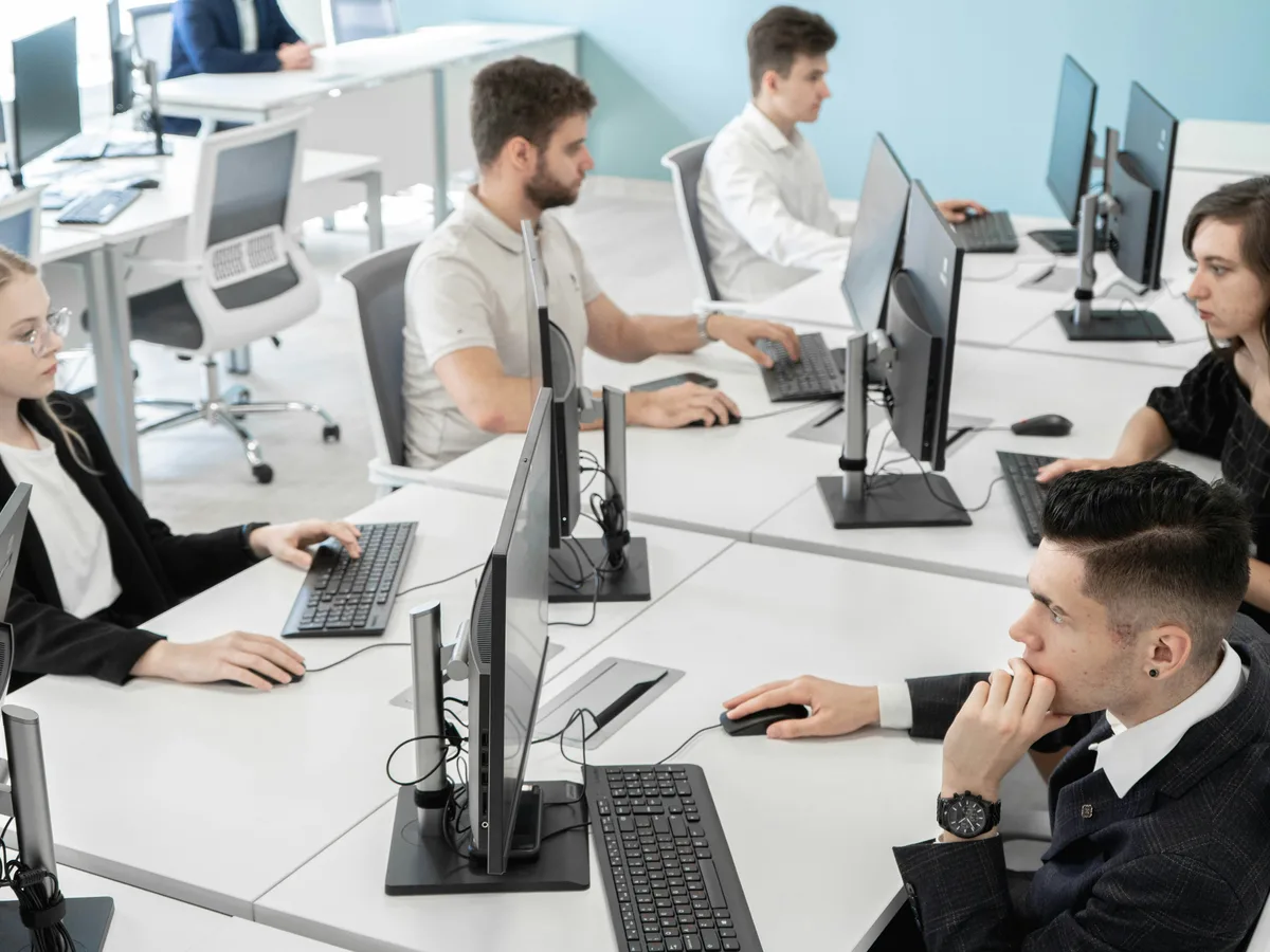 Escritório com várias estações de trabalho e computadores em uso
